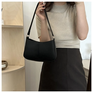 Détail du sac hobo noir minimaliste avec bandoulière réglable et boucle en métal doré