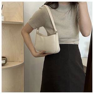 Sac baguette chic blanc crème avec bandoulière large porté à l'épaule pour un style moderne