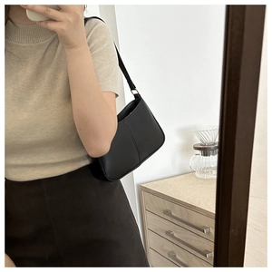 Vue détaillée du sac à bandoulière demi-lune noir avec boucles dorées et cuir lisse
