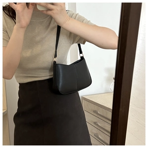 Selfie miroir montrant le sac porté épaule noir mat avec des boucles en métal doré