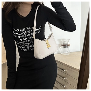 Détail du sac croissant blanc avec fermoir géométrique doré et bandoulière