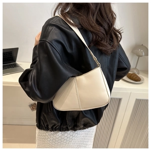 Détail du sac bandoulière en cuir blanc cassé avec coutures verticales sur un mannequin