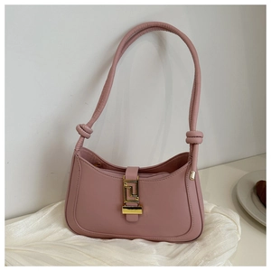 Detail of pink leather baguette bag with golden metal buckle and knot strap detail