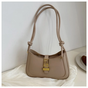 Detail of hobo bag featuring decorative knot strap and gold geometric metal buckle closure