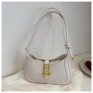 Detail view of cream white half-moon shoulder bag with golden geometric clasp