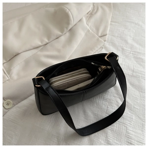 Vue intérieure montrant la capacité du sac baguette noir avec smartphone et portefeuille