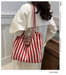 Detail of red and white striped canvas tote bag showing the textured fabric and shoulder strap