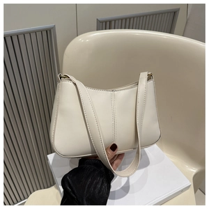 Détail d'un sac baguette en cuir PU crème avec bandoulière épaisse et coutures verticales