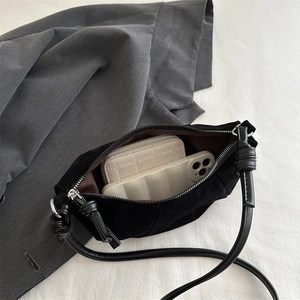 Vintage black suede hobo bag with knotted strap showing internal storage capacity