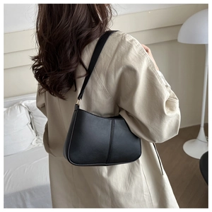 Détail du sac demi-lune noir en similicuir avec boucles métalliques dorées élégantes