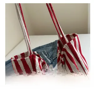 Close-up of red and white striped canvas tote bag showing stitching and fabric detail
