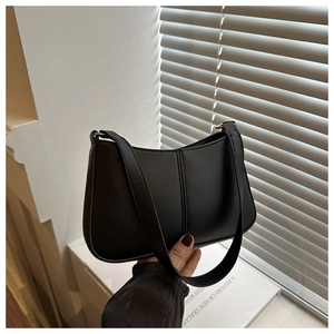 Gros plan d'un sac à bandoulière noir minimaliste avec détails de couture verticale