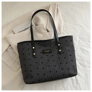 Detail of grey striped tote bag with bow prints and branded leather logo patch
