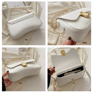 Detail view of white minimalist shoulder bag with gold hardware and chain strap accents