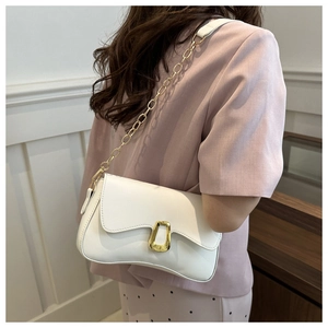 Close-up of a white textured shoulder bag featuring an elegant gold-tone horseshoe buckle