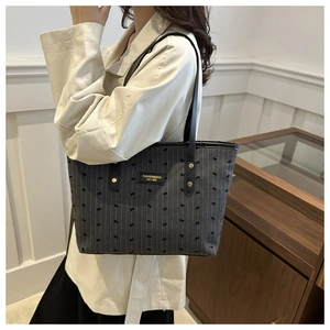 Detail view of grey striped tote bag with bow print and leather shoulder straps