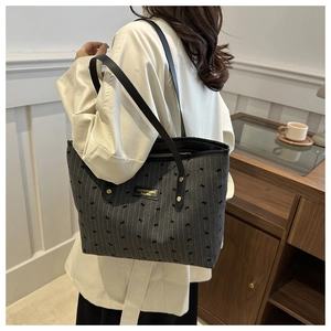 Macro shot of stylish tote bag with black bow print and fashion label on canvas material
