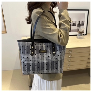 Detail showing checkered fabric texture and black dot pattern of the large tote bag