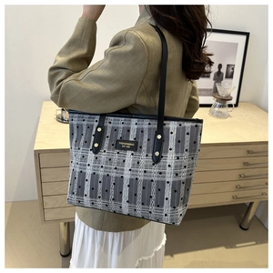 Fashionable black checkered tote bag with leather handles shown in a lifestyle setting