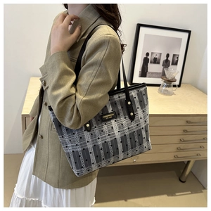 Detail of grey houndstooth tote bag with polka dots, leather tag and golden rivets