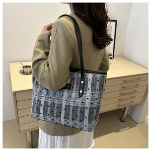 Detail view of large grey polka dot tote bag showing premium canvas texture and leather straps