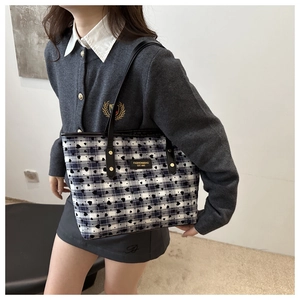 Detail of blue and white checkered tote bag with heart print and fashion label detail