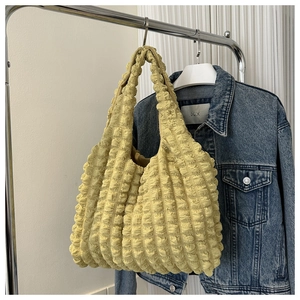 Détail du sac fourre-tout jaune gingembre avec texture pop-corn et design plissé