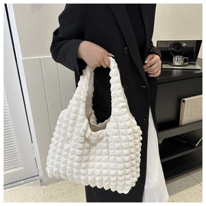 Nahaufnahme der weißen Cloud-Tasche mit der einzigartigen Waffelstruktur und weichem Design