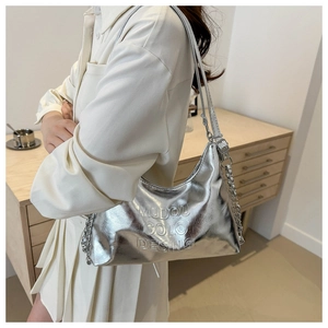Dettaglio della borsa hobo argento metallizzato con scritta a rilievo e catena