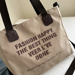Minimalist khaki canvas tote bag with brown straps and stylish letter print design