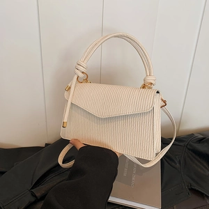 Chic beige pleated crossbody bag with top handle and vertical ribbed texture for women