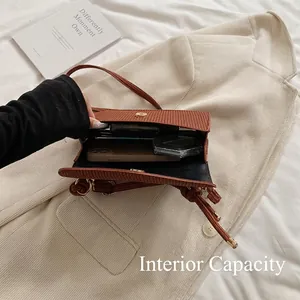 Brown textured leather crossbody bag showing internal capacity for phone and cosmetics