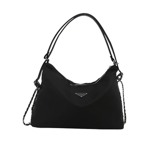 Minimalist black nylon half-moon tote bag with silver chain straps and metal triangle badge