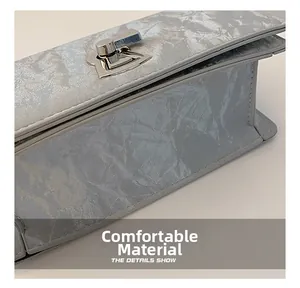 Detail shot of grey wrinkled texture fabric and silver metal twist lock on square bag