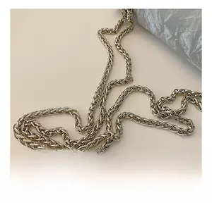 Detailed macro shot of silver metal chain strap and crinkled texture fabric on the bag