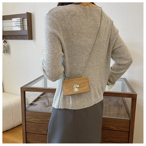 Detail of tan square crossbody bag featuring wrinkled texture and silver keyhole lock