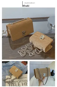Detail view of khaki square chain bag with wrinkled leather texture and metal strap