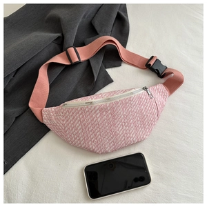 Détail de la texture en tweed rose et blanc sur un sac de poitrine tendance pour femme