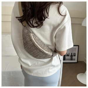 Détail du tissage et fermeture éclair argentée sur sac banane porté par un mannequin