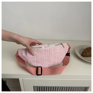 Détail d'un sac de poitrine en tweed rose et blanc texturé avec large bandoulière