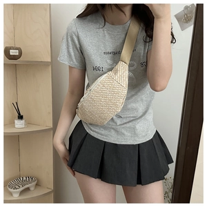 Détail du sac de poitrine minimaliste en paille tressée avec bandoulière réglable