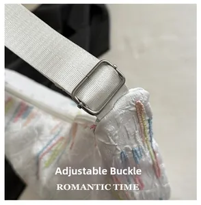 Detail of adjustable metal buckle on white oxford tote bag with colorful embroidery