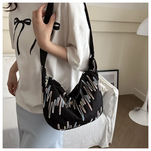Detail of colorful wavy embroidery on a black textured oxford cloth tote shoulder bag