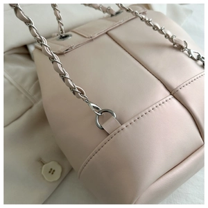 Dettaglio della borsa a tracolla in pelle intrecciata rosa chiaro con catena