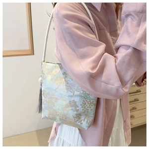 Detail der Tasche im chinesischen Stil mit goldenem Jacquard und grauer Quastenverzierung