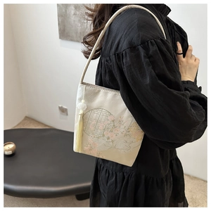 Details von Blumenstickerei und weißer Quaste an der chinesischen Eimer-Tasche