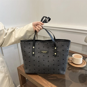 Chic striped tote bag with butterfly patterns and gold hardware in a lifestyle setting