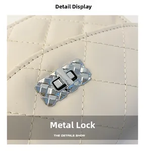 Detailed close-up of the silver metal lock with woven texture on a beige quilted bag