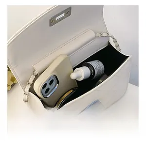 Interior view showing the capacity of a white quilted chain bag for cosmetics and phone