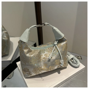 Detail of New Chinese style handbag featuring golden landscape brocade and pearl drawstring